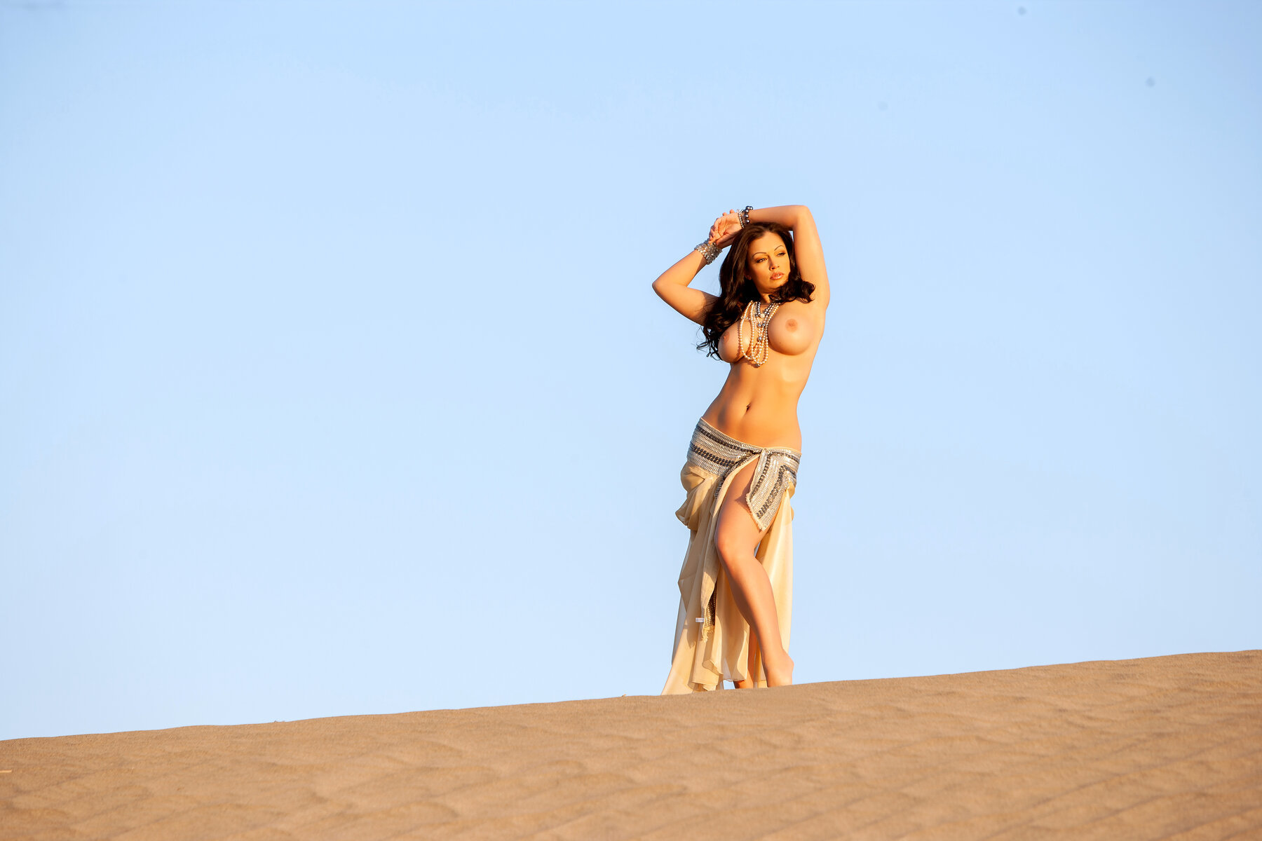 Stunning diva Aria Giovanni sensually poses in the desert with her enormous boobs