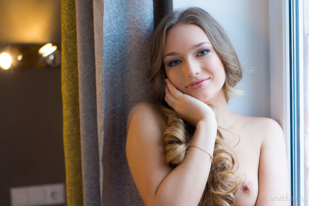 Beautiful teen Amy Moore poses totally naked on a windowsill during the day