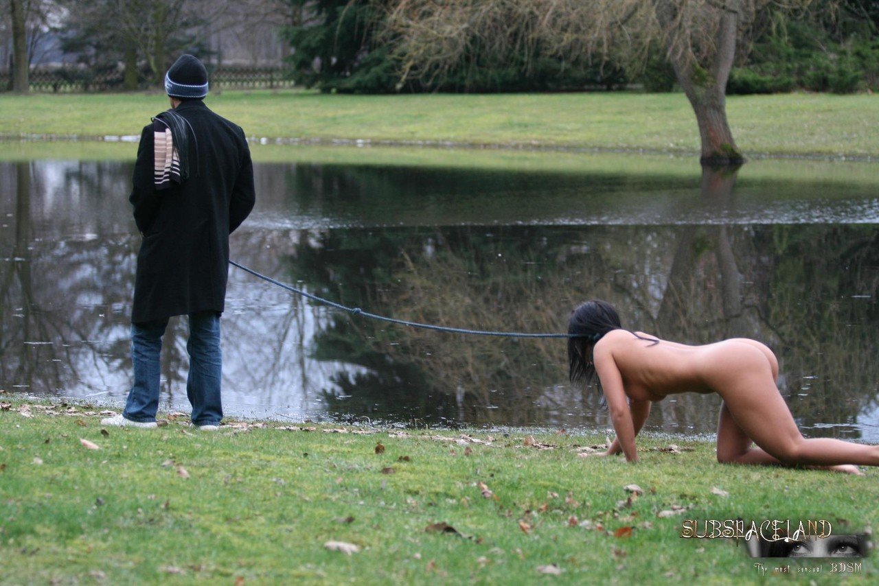 Female sub Barbara Devil crawls on a leash before being flogged on a cold day