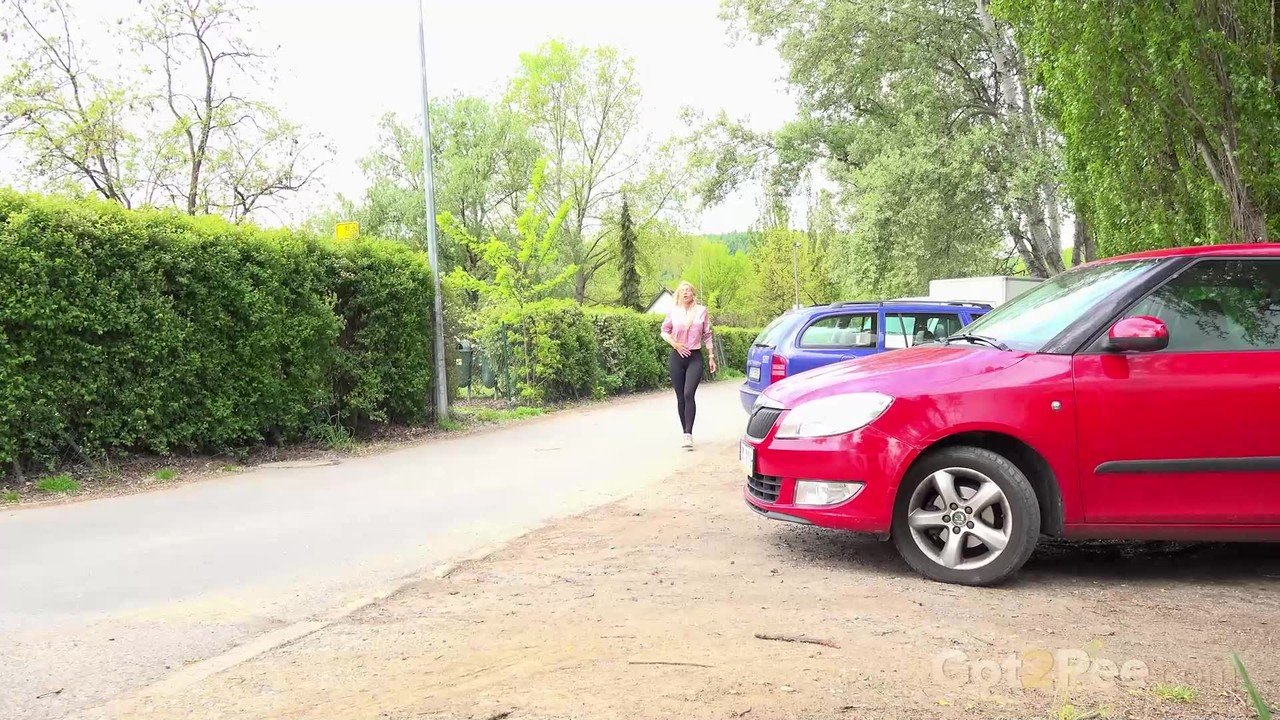 Blonde girl Emily Bright pulls down leggings beside a car for an urgent pee