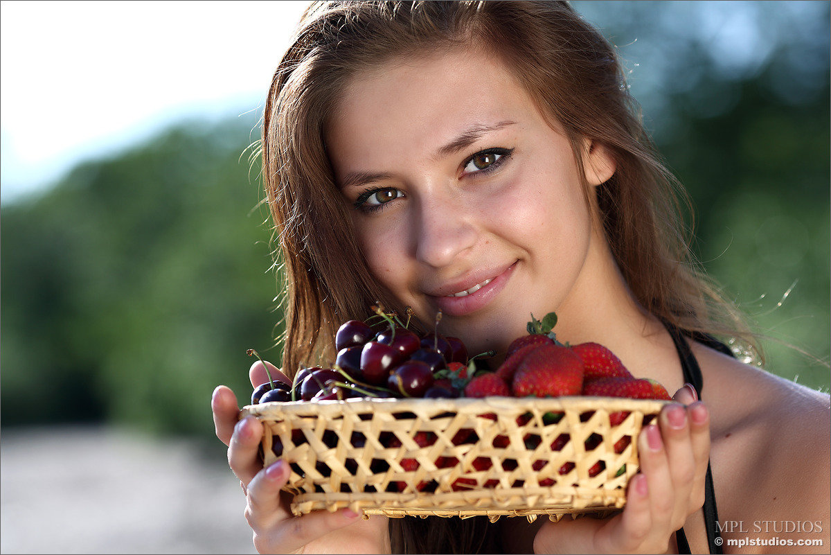 Nice teen girl puts down a basket of fruit and strips naked on a sandy beach