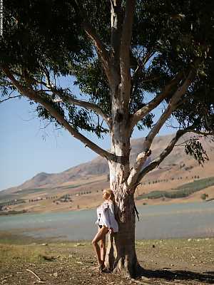 Darya enjoying the sunshine nude by a tree