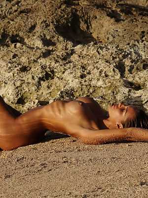 Amber A posing nude sensually on a rocky beach