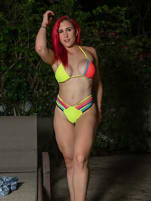 Redhead Jennifer Light spreads her legs, stripping her colorful bikini