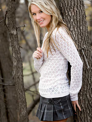 Jewell takes off her short skirt and sweater in the woods