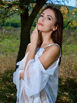 Alice Wonder removes her transparent dress under a tree to show her naked body