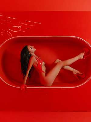 Ashlyn Chere fascinates us with her nude figure in a red photo studio