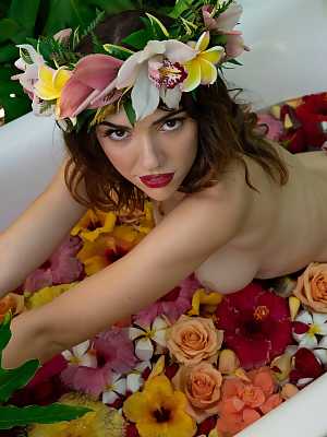 Azura Grace soaks her nude figure in a flower bath