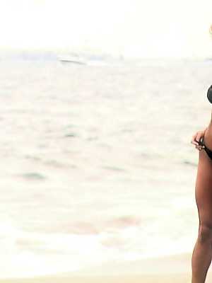 Bodybuilder Abby Marie flaunts her sturdy body in a black bikini on the beach