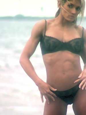 Bodybuilder Abby Marie flaunts her sturdy body in a black bikini on the beach