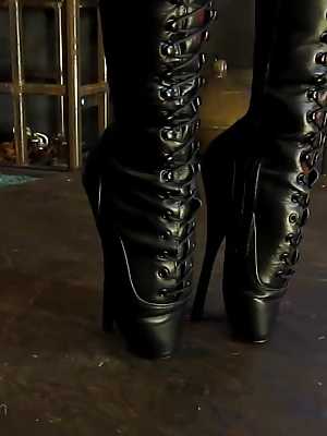Female slave Abigail Dupree stands on her tiptoes while restrained in leather
