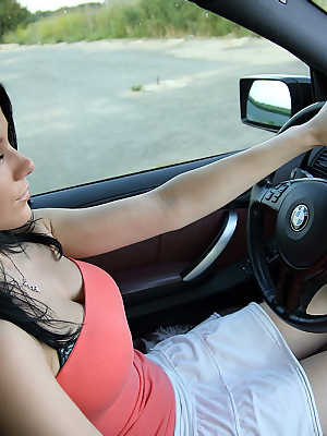 Pretty brunette uncovers her big boobs while driving a vehicle