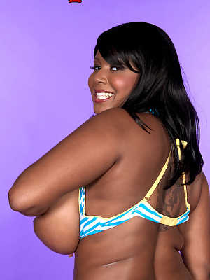 Chubby black girl Aileen Ghettman licks a nipple after loosing her hooters