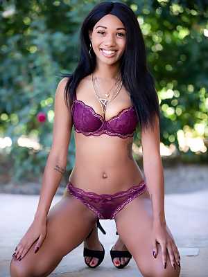 Ebony model Alexis Avery removes bra and panty set for nude poses on patio