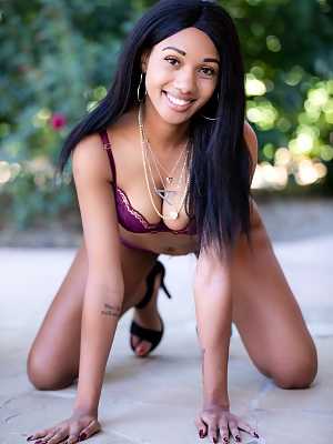 Ebony model Alexis Avery removes bra and panty set for nude poses on patio
