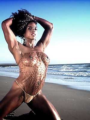 Bodybuilder Alexis Ellis shows her six pack and pierced nipples on the beach