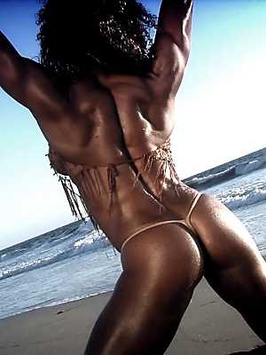 Bodybuilder Alexis Ellis shows her six pack and pierced nipples on the beach