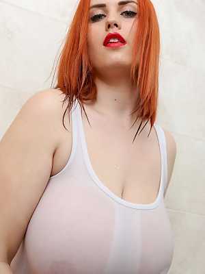 Sexy redhead Alexsis Faye presses her hooters up against a glass shower wall