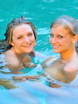 Blonde lesbians work on the flexibility before getting into a pool