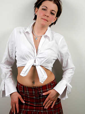 Shy and horny schoolgirl Alicia Avery posing against the wall in short skirt