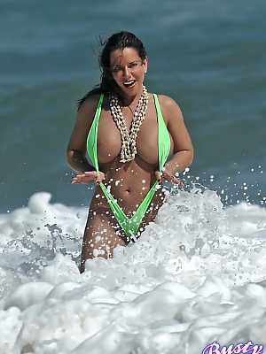 Amply endowed female Alicia Dimarco struts in a v-bikini amid foamy surf