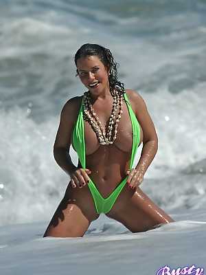 Amply endowed female Alicia Dimarco struts in a v-bikini amid foamy surf