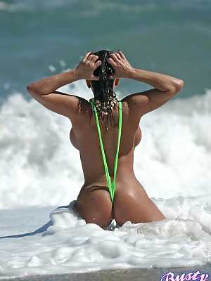 Amply endowed female Alicia Dimarco struts in a v-bikini amid foamy surf