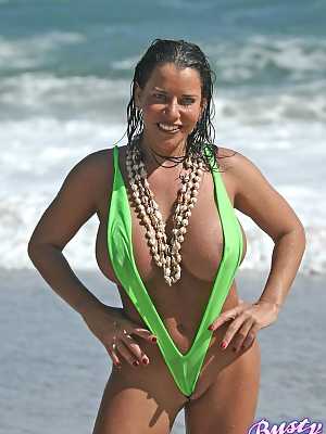 Amply endowed female Alicia Dimarco struts in a v-bikini amid foamy surf