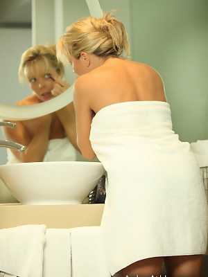 Dirty blond amateur Amber Lynn Bach admires her nude body in a bathroom mirror