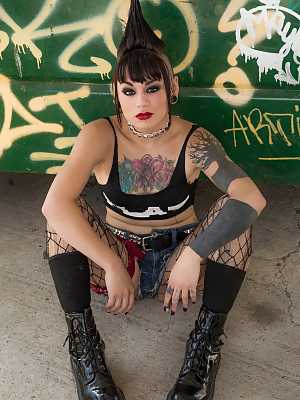 Mohawked punk girl Amelia Dire drops fishnets to spread luscious ass in alley