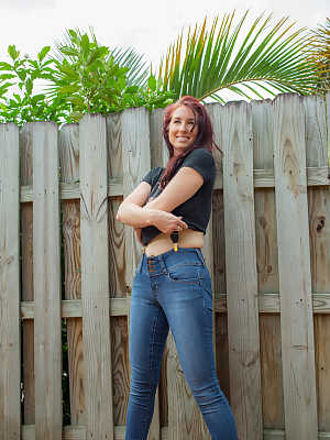 Hot redhead Andy Adams loses her t-shirt & jeans in the yard to pose naked