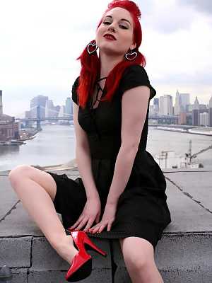 Redheaded model strips to back seam nylons and heels on a rooftop