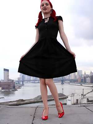 Redheaded model strips to back seam nylons and heels on a rooftop