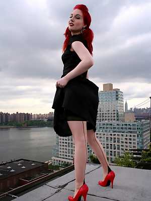 Redheaded model strips to back seam nylons and heels on a rooftop