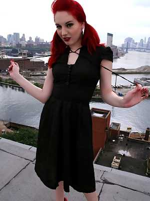 Redheaded model strips to back seam nylons and heels on a rooftop