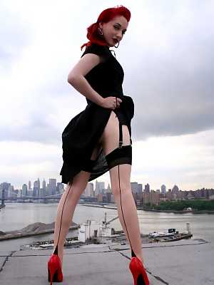 Redheaded model strips to back seam nylons and heels on a rooftop