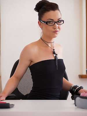 Nerdy MILF in a garter belt Angelique Duval takes a dong at her workplace