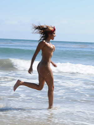 Big boobed Latina chick Anita Toro walks along a beach in the nude