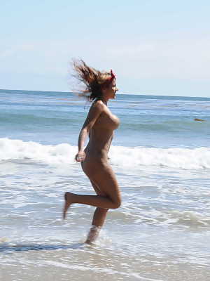 Big boobed Latina chick Anita Toro walks along a beach in the nude