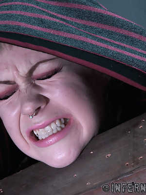 Blonde girl Anna Tyler grimaces in pain while being tortured in a dungeon