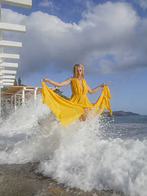 Blonde hottie Milena Angel shows her big tits under a dock in a yellow dress