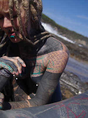 Tattooed girl jerks and sucks a tattooed penis near the ocean