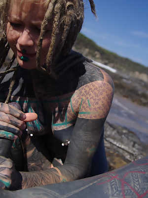 Tattooed girl jerks and sucks a tattooed penis near the ocean