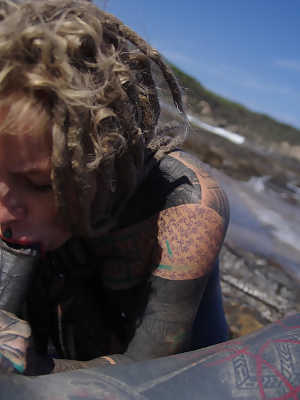 Tattooed girl jerks and sucks a tattooed penis near the ocean