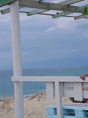 Heavily tattooed girl models a bikini in heels on a beach patio