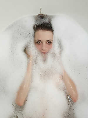 Naturally busty teenage girlfriend taking a bubble bath and posing nude