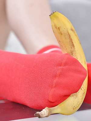 Leggy babe Ariana Brown squashing banana with barefeet after socks removal