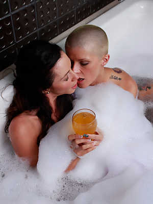 Buxom pornstars Ariella Ferrera and Joslyn James toy each other in a foamy tub