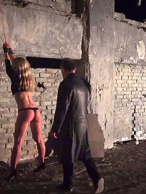 Sex slaves giving their BDSM handler a double blowjob after a whipping