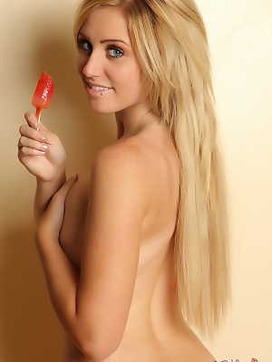 Solo girl with long blonde hair licks a popsicle in striped thigh high socks